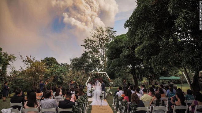 Mặc núi lửa phun trào dữ dội phía sau, đôi vợ chồng vẫn bình tĩnh tổ chức cho xong đám cưới đã rồi tính - Ảnh 2.