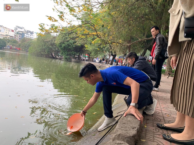 Dù nhóm tình nguyện viên hỗ trợ tiễn ông Công ông Táo về trời, một số người dân đứng trên cầu vẫn thản nhiên ném bát hương xuống sông - Ảnh 17.