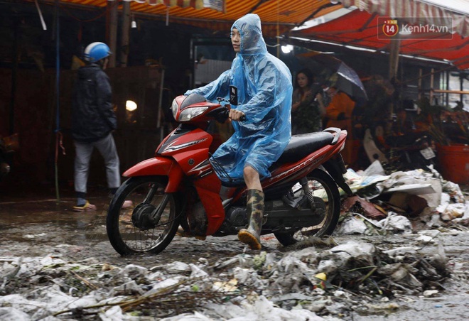 Chợ hoa Quảng An ngập trong rác, nhiều người vẫn tranh thủ đội mưa đi mua hoa Tết - Ảnh 4.