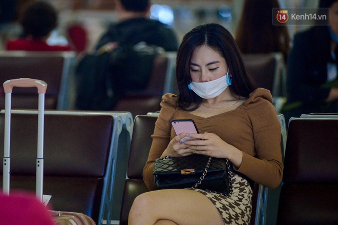 Hành khách đeo khẩu trang kín mít vì lo lắng dịch virus Corona khi chuẩn bị rời sân bay Nội Bài trước thời khắc đón năm mới - Ảnh 4.