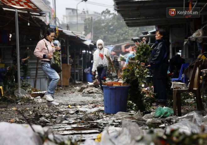 Chợ hoa Quảng An ngập trong rác, nhiều người vẫn tranh thủ đội mưa đi mua hoa Tết - Ảnh 1.