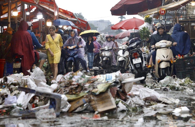 Chợ hoa Quảng An ngập trong rác, nhiều người vẫn tranh thủ đội mưa đi mua hoa Tết - Ảnh 2.