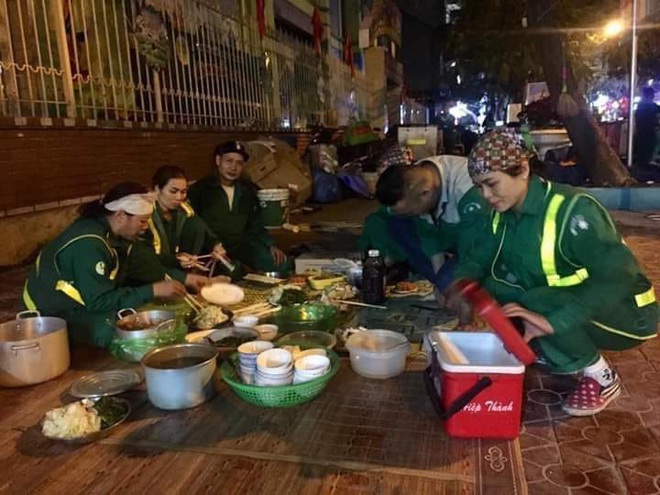 Xúc động hình ảnh bữa cơm tất niên chớp nhoáng ngay ngoài đường phố của các chị lao công tối 30 Tết - Ảnh 2.