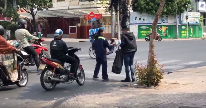 Clip: Soái ca đội nắng phát khẩu trang miễn phí cho người dân phòng virus corona trên đường phố Sài Gòn - Ảnh 3.