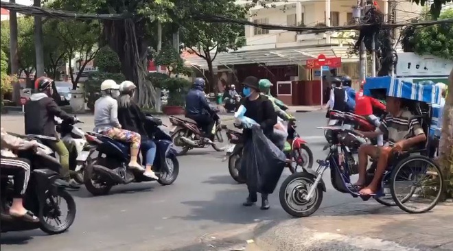 Clip: Soái ca đội nắng phát khẩu trang miễn phí cho người dân phòng virus corona trên đường phố Sài Gòn - Ảnh 4.