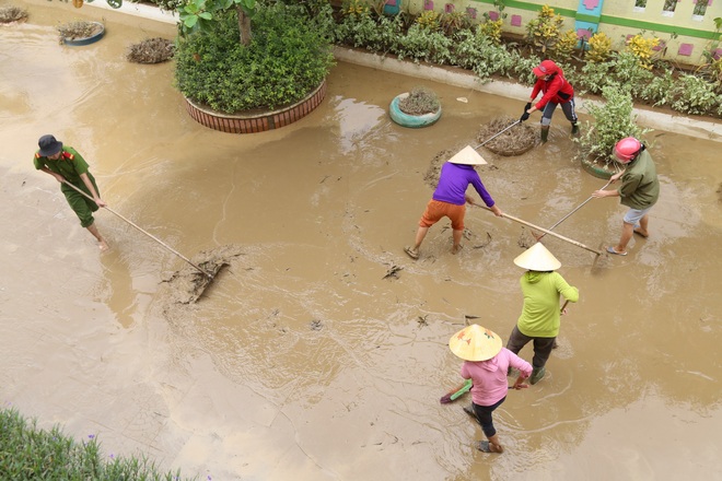 Giáo viên, phụ huynh Quảng Bình hối hả dọn dẹp trường lớp sau lũ - Ảnh 1.