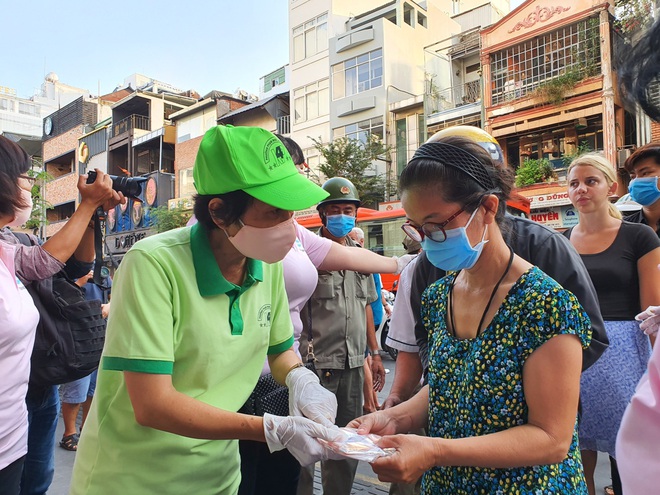 TP.HCM: Người dân, khách nước ngoài thích thú xếp hàng nhận 1.000 khẩu trang vải miễn phí giữa đại dịch Covid-19 - Ảnh 3.