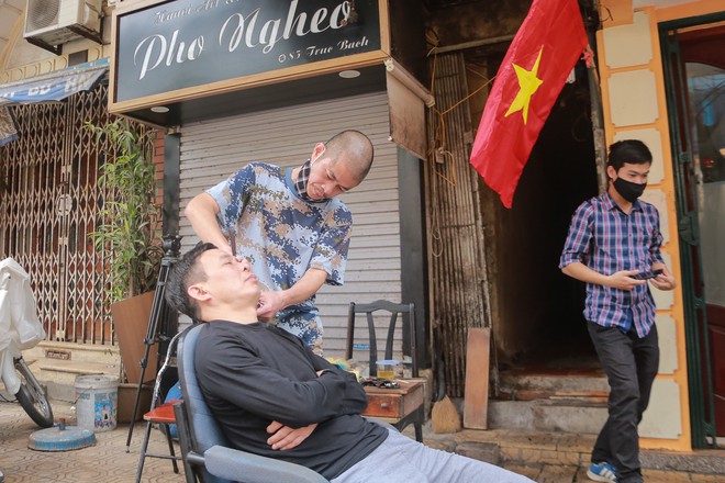 Ảnh: H&agrave;ng qu&aacute;n xung quanh khu vực phố Tr&uacute;c Bạch tất bật dọn dẹp, chuẩn bị đ&oacute;n kh&aacute;ch trở lại sau khi lệnh c&aacute;ch ly được gỡ bỏ - Ảnh 2.