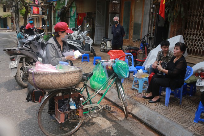 Ảnh: H&agrave;ng qu&aacute;n xung quanh khu vực phố Tr&uacute;c Bạch tất bật dọn dẹp, chuẩn bị đ&oacute;n kh&aacute;ch trở lại sau khi lệnh c&aacute;ch ly được gỡ bỏ - Ảnh 3.