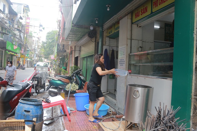 Ảnh: H&agrave;ng qu&aacute;n xung quanh khu vực phố Tr&uacute;c Bạch tất bật dọn dẹp, chuẩn bị đ&oacute;n kh&aacute;ch trở lại sau khi lệnh c&aacute;ch ly được gỡ bỏ - Ảnh 6.