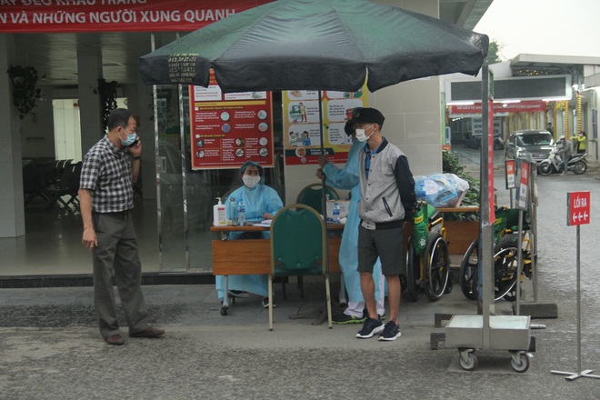 Cán bộ nhân viên BV Bạch Mai đội mưa kiểm tra thân nhiệt từng người vào viện, ngừng khám theo yêu cầu để chống dịch COVID-19 - Ảnh 17.