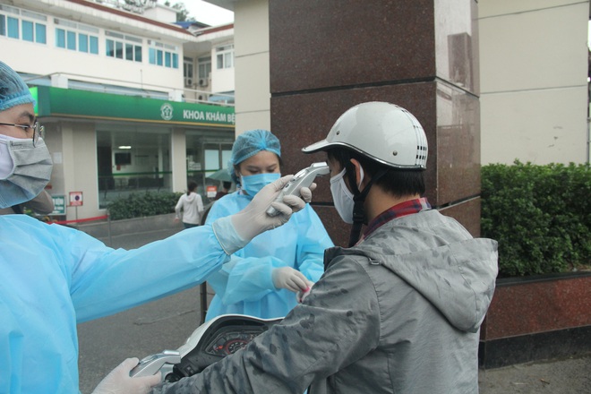 Cán bộ nhân viên BV Bạch Mai đội mưa kiểm tra thân nhiệt từng người vào viện, ngừng khám theo yêu cầu để chống dịch COVID-19 - Ảnh 9.