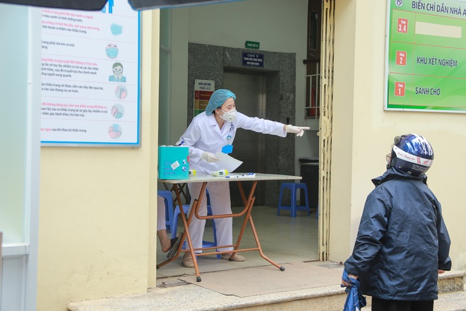 Ảnh: Lo ngại dịch COVID-19 bùng phát, Hà Nội tiến hành sàng lọc và khai báo tiền sử dịch tễ ngay từ cổng bệnh viện - Ảnh 2.