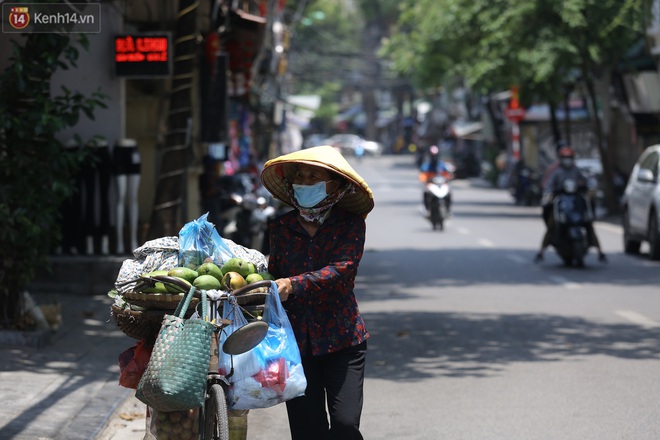 Ảnh: Người dân Thủ đô vật vã chống chọi với nắng nóng kinh hoàng, trùm cả mảnh vải hay đội khăn ướt để giải nhiệt - Ảnh 5.