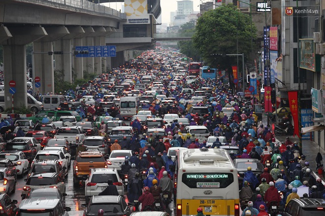 Hà Nội tắc đường kinh hoàng, người dân khổ sở đi làm trong cơn mưa lớn - Ảnh 3.