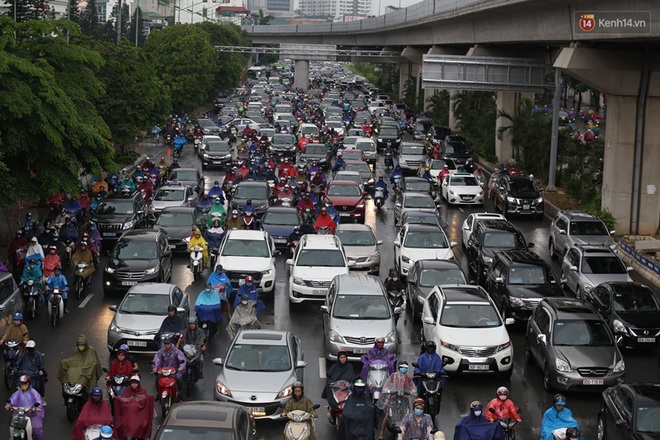 Hà Nội tắc đường kinh hoàng, người dân khổ sở đi làm trong cơn mưa lớn - Ảnh 4.