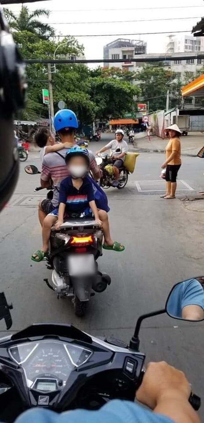 Một tay bế con một tay lái xe máy, phía sau còn cho con trai ngồi ...