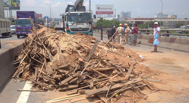 Xe tải rớt bánh lật trên quốc lộ 1A ở Sài Gòn, nhiều người thoát chết, giao thông ùn ứ kéo dài   - Ảnh 1.