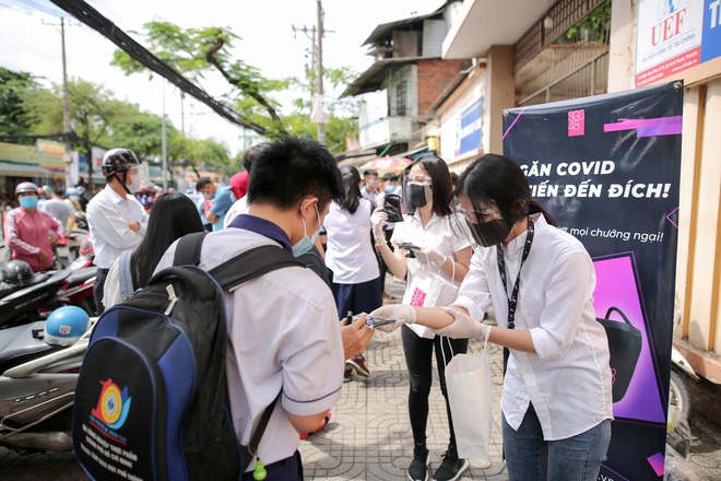 Vượt qua cơn mưa chiều, SGO48 đội ô đi phát khẩu trang cho sĩ tử - Ảnh 2.