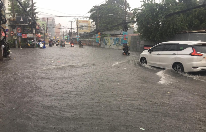 Nhiều tuyến đường ở Sài Gòn lại thành sông sau mưa lớn, các cửa hàng phải đóng cửa vì nước tràn vào nhà - Ảnh 1.