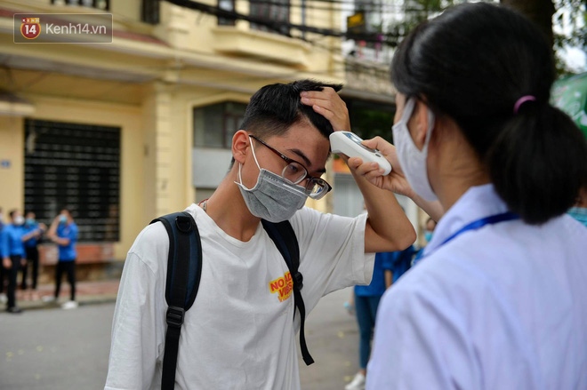 Chùm ảnh chưa từng có trong lịch sử: Thí sinh đeo khẩu trang kín mít, xếp hàng đo thân nhiệt đi thi THPT Quốc gia - Ảnh 1.