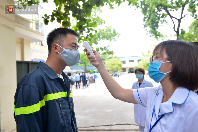 Chùm ảnh chưa từng có trong lịch sử: Thí sinh đeo khẩu trang kín mít, xếp hàng đo thân nhiệt đi thi THPT Quốc gia - Ảnh 6.