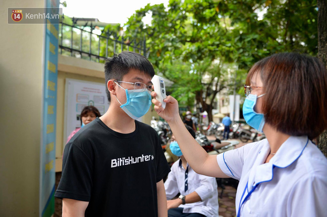 Chùm ảnh chưa từng có trong lịch sử: Thí sinh đeo khẩu trang kín mít, xếp hàng đo thân nhiệt đi thi THPT Quốc gia - Ảnh 1.