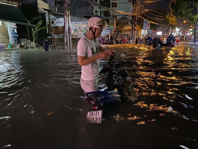 Nhiều tuyến đường Sài Gòn ngập lút bánh xe sau mưa lớn, nước chảy cuồn cuộn như lũ - Ảnh 5.