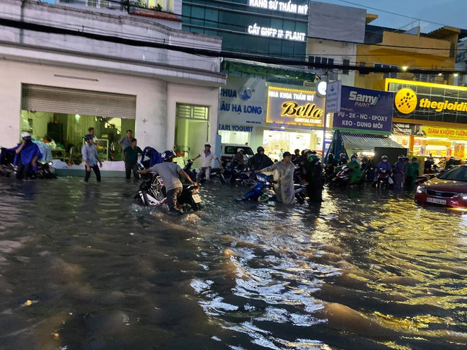 Nhiều tuyến đường Sài Gòn ngập lút bánh xe sau mưa lớn, nước chảy cuồn cuộn như lũ - Ảnh 14.