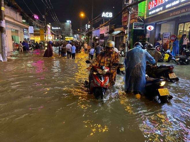 Nhiều tuyến đường Sài Gòn ngập lút bánh xe sau mưa lớn, nước chảy cuồn cuộn như lũ - Ảnh 8.