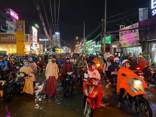 Nhiều tuyến đường Sài Gòn ngập lút bánh xe sau mưa lớn, nước chảy cuồn cuộn như lũ - Ảnh 13.