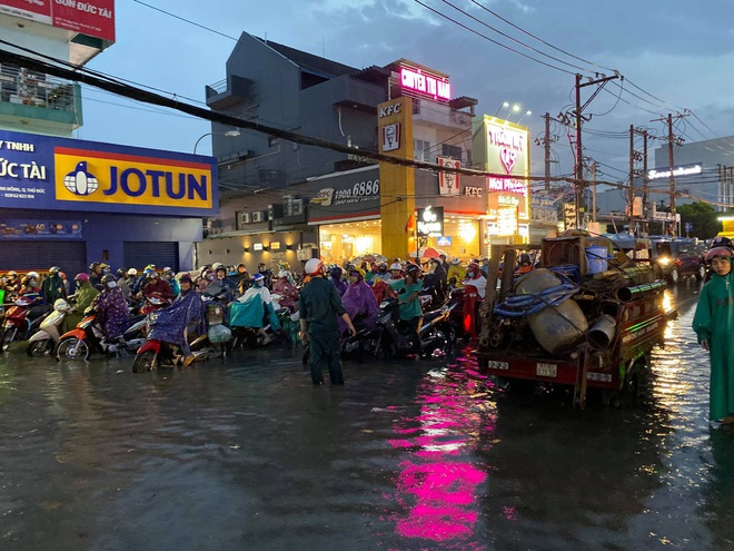 Nhiều tuyến đường Sài Gòn ngập lút bánh xe sau mưa lớn, nước chảy cuồn cuộn như lũ - Ảnh 13.