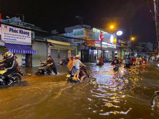 Nhiều tuyến đường Sài Gòn ngập lút bánh xe sau mưa lớn, nước chảy cuồn cuộn như lũ - Ảnh 3.