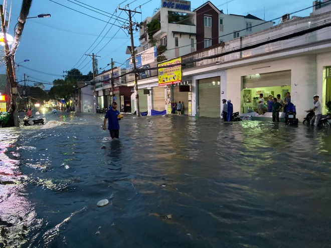 Nhiều tuyến đường Sài Gòn ngập lút bánh xe sau mưa lớn, nước chảy cuồn cuộn như lũ - Ảnh 14.