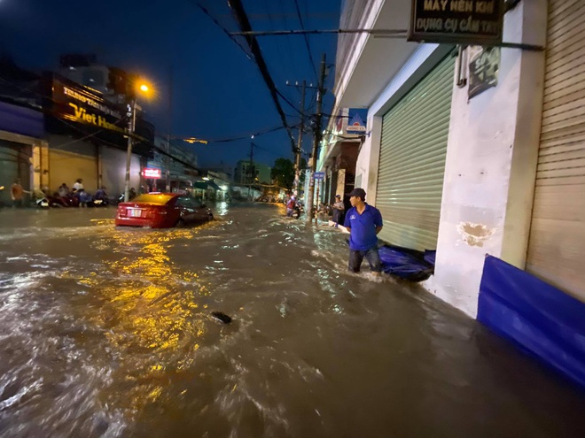 Nhiều tuyến đường Sài Gòn ngập lút bánh xe sau mưa lớn, nước chảy cuồn cuộn như lũ - Ảnh 11.