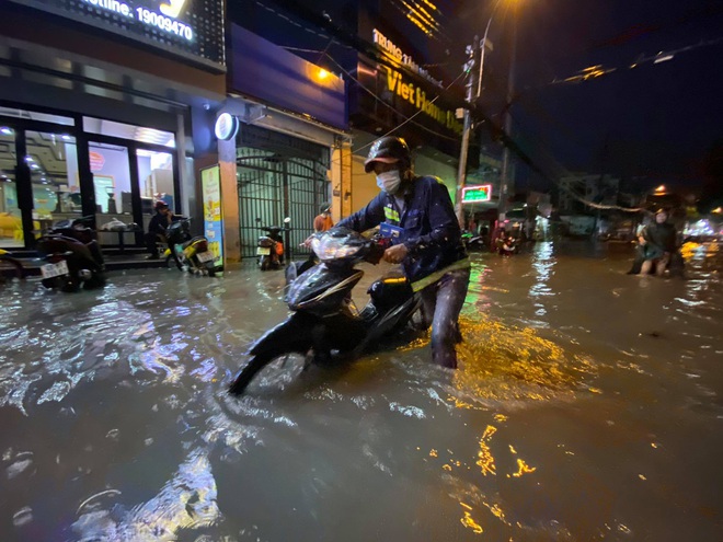 Nhiều tuyến đường Sài Gòn ngập lút bánh xe sau mưa lớn, nước chảy cuồn cuộn như lũ - Ảnh 8.