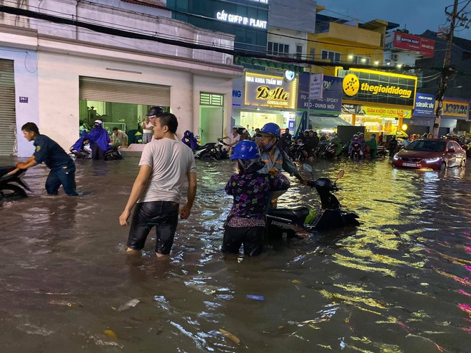 Nhiều tuyến đường Sài Gòn ngập lút bánh xe sau mưa lớn, nước chảy cuồn cuộn như lũ - Ảnh 14.