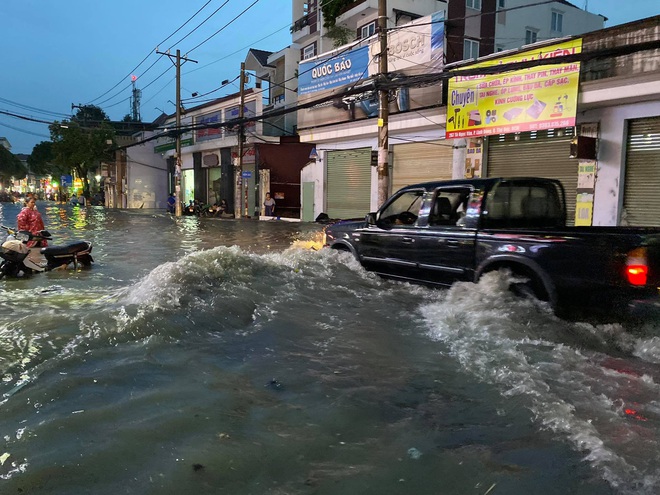 Nhiều tuyến đường Sài Gòn ngập lút bánh xe sau mưa lớn, nước chảy cuồn cuộn như lũ - Ảnh 14.