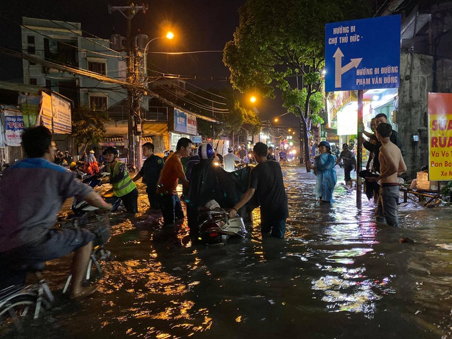 Nhiều tuyến đường Sài Gòn ngập lút bánh xe sau mưa lớn, nước chảy cuồn cuộn như lũ - Ảnh 3.