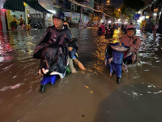 Nhiều tuyến đường Sài Gòn ngập lút bánh xe sau mưa lớn, nước chảy cuồn cuộn như lũ - Ảnh 5.