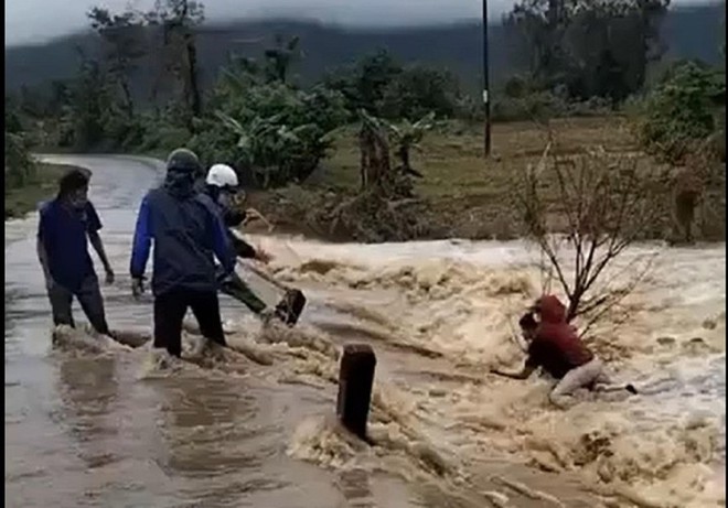 Thót tim cảnh giải cứu người phụ nữ giữa dòng nước lũ cuồn cuộn - Ảnh 1.