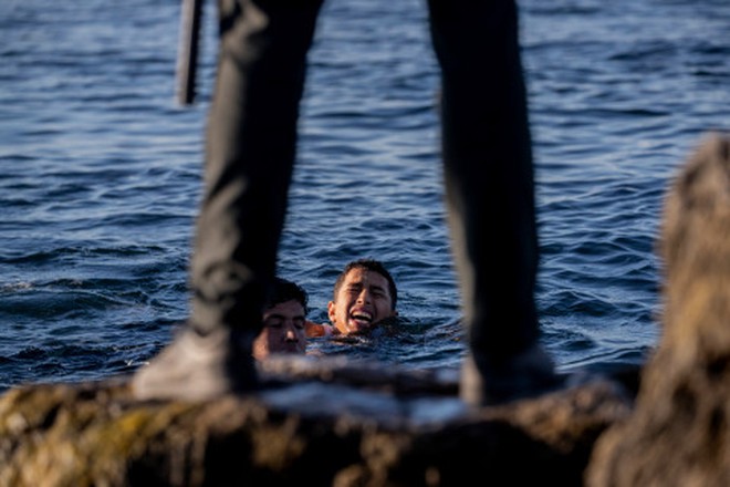 Khoảnh khắc cậu bé di cư bật khóc giữa biển nước mênh mông, dùng chai nhựa để bơi đến miền đất hứa gây chấn động thế giới - Ảnh 4.