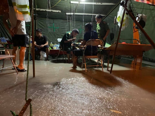 Xót xa hình ảnh chiến sĩ công an dầm mưa tại chốt phòng dịch Covid-19: Những bữa cơm ăn vội, mưa xối trên đầu và nước ngập dưới chân - Ảnh 1. Xót xa hình ảnh chiến sĩ công an dầm mưa tại chốt phòng dịch Covid-19: Những bữa cơm ăn vội, mưa xối trên đầu và nước ngập dưới chân - Ảnh 1.