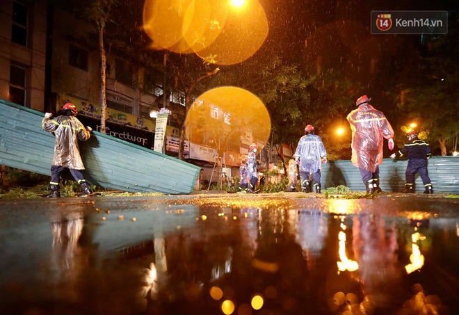 Ảnh: Cảnh sát PCCC&CHCN Hà Nội đội mưa để dọn tấm tôn lớn bay xuống đường - Ảnh 4.