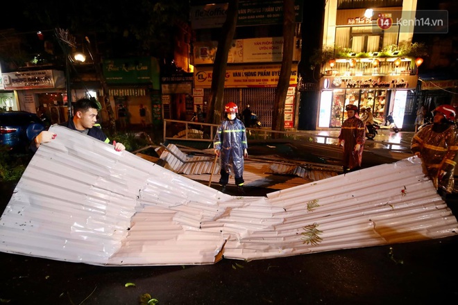 Ảnh: Cảnh sát PCCC&CHCN Hà Nội đội mưa để dọn tấm tôn lớn bay xuống đường - Ảnh 1.