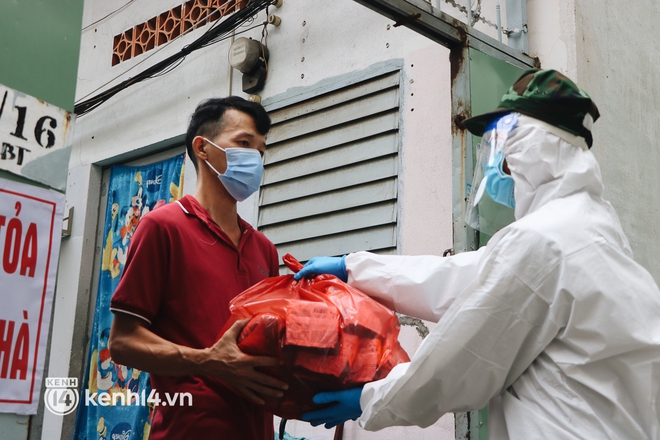 Mặc mưa to và trời tối, lực lượng quân đội vẫn tiếp tục đi từng hẻm, đến từng nhà trao thực phẩm cho người dân - Ảnh 8.