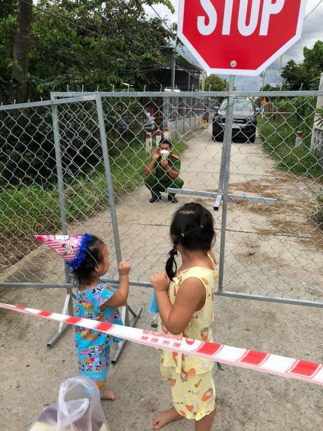 Chiến sĩ CA thổi nến mừng sinh nhật con gái ngay tại hàng rào phong tỏa, cái vẫy tay từ xa khiến bao người thổn thức - Ảnh 2.