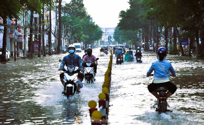 Đường phố Cần Thơ thành sông, người dân lội nước đi làm - Ảnh 1.