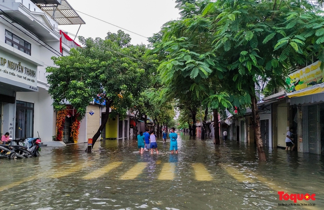 Khách Tây trải nghiệm đi thuyền giữa phố, người dân giăng lưới bắt cá bên Kinh thành Huế sau mưa - Ảnh 4.