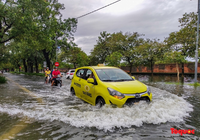 Khách Tây trải nghiệm đi thuyền giữa phố, người dân giăng lưới bắt cá bên Kinh thành Huế sau mưa - Ảnh 2.